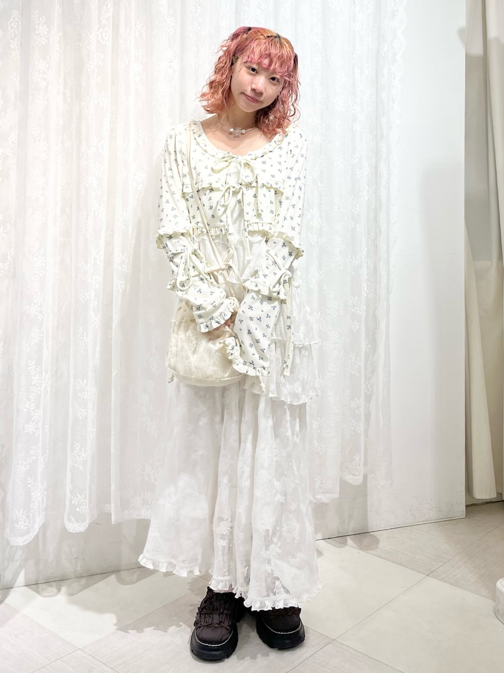 ホワイト系のカーディガン/ボレロ、ホワイト系のワンピース、ホワイト系のショルダーバッグを着用したレディースの夏コーディネートの2枚目の写真