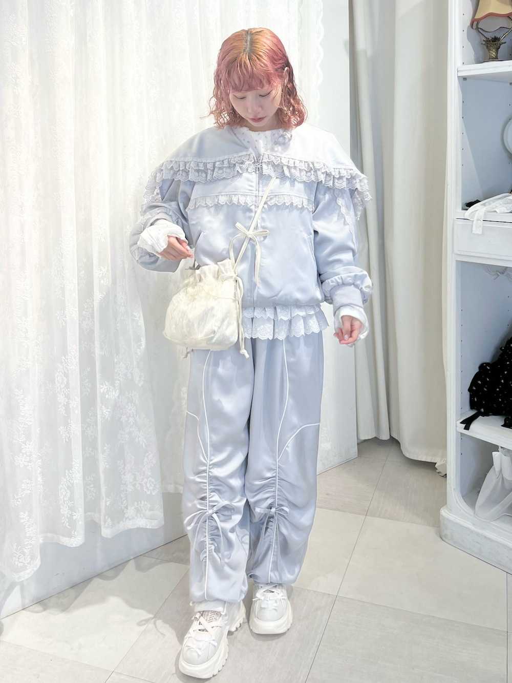 ブルー系のその他パンツ、グレー系のブルゾン、ホワイト系のショルダーバッグを着用したレディースの春コーディネートの2枚目の写真