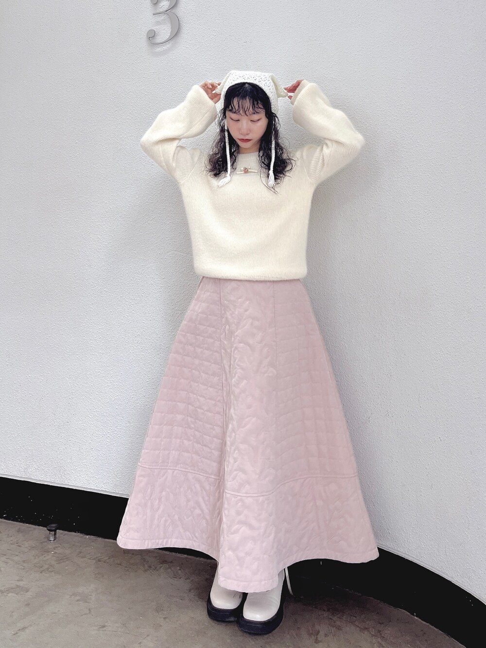ホワイト系のニット/セーター、ピンク系のスカート、ホワイト系のブーツを着用したレディースの秋コーディネートの2枚目の写真