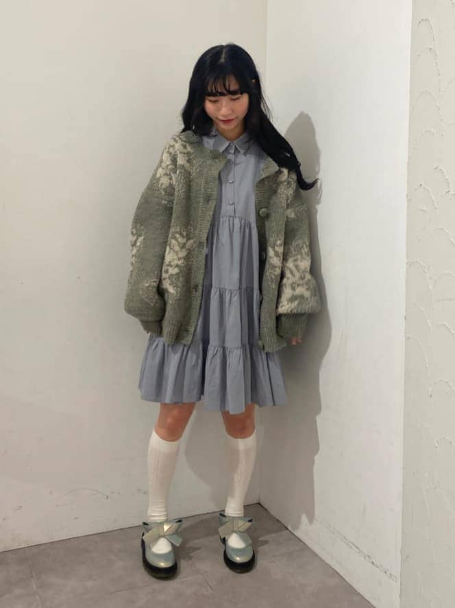 ブルー系のワンピース、ホワイト系のパンプス、グレー系のカーディガン/ボレロを着用したレディースの秋コーディネートの2枚目の写真