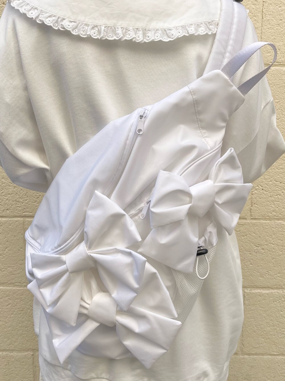 ホワイト系のシャツ/ブラウス、ホワイト系のスウェット、ホワイト系のショルダーバッグを着用したレディースの冬コーディネートの5枚目の写真