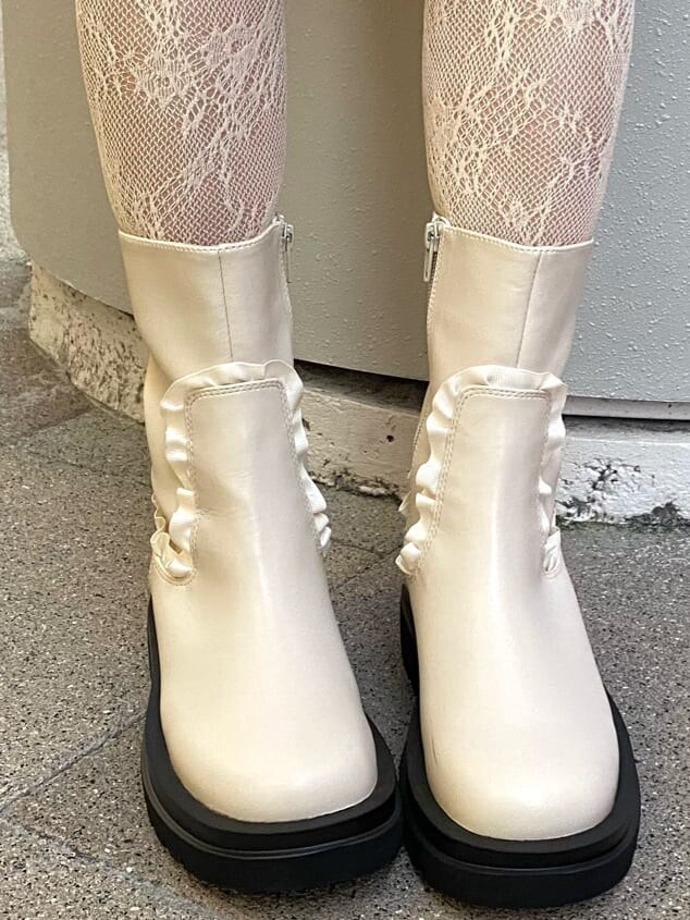 ホワイト系のブーツ、ホワイト系のスカート、ホワイト系のニット/セーターを着用したレディースの秋コーディネートの4枚目の写真