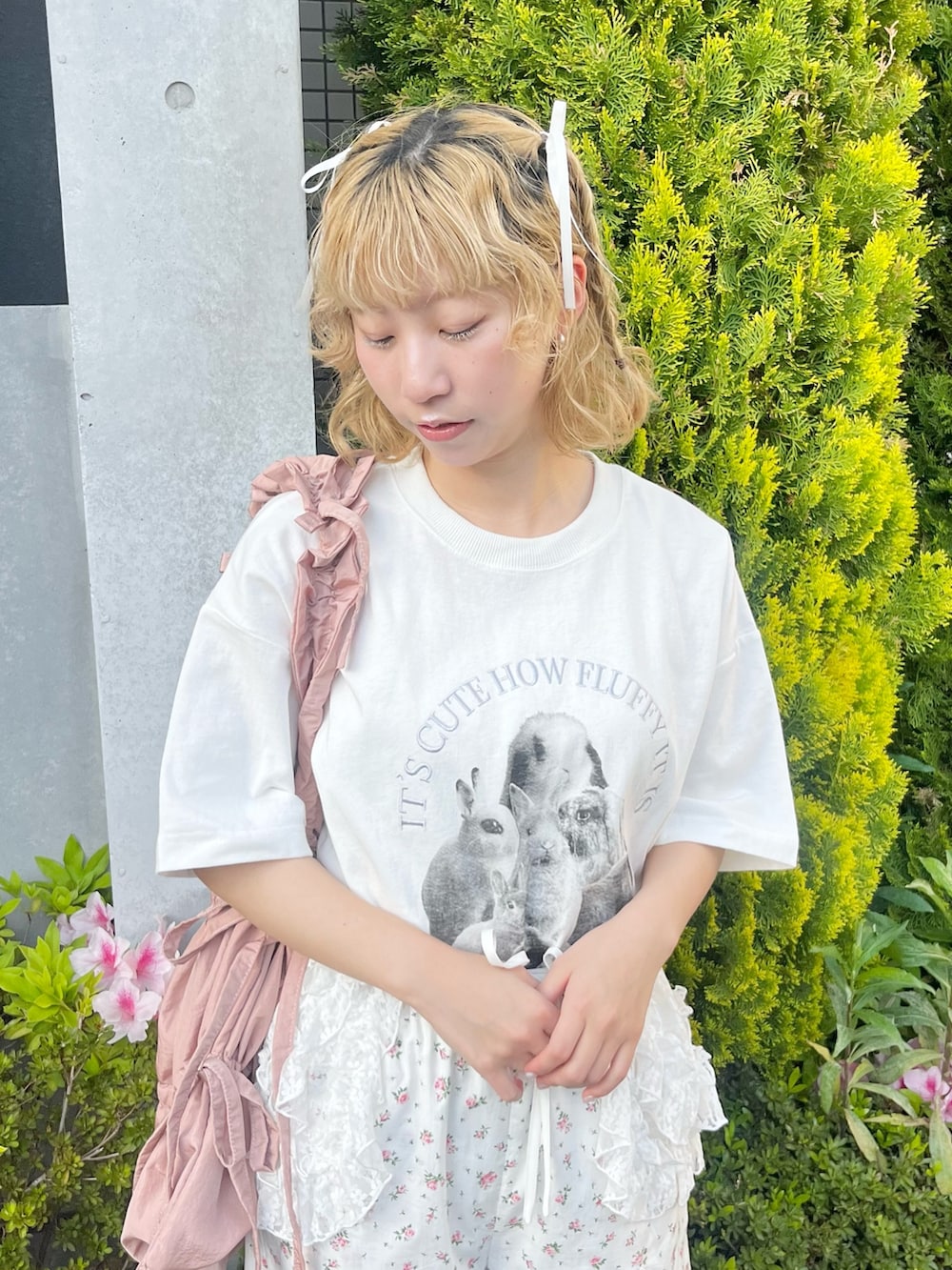 ホワイト系のTシャツ/カットソー、ホワイト系のスラックス、ピンク系のトートバッグを着用したレディースの春コーディネートの6枚目の写真