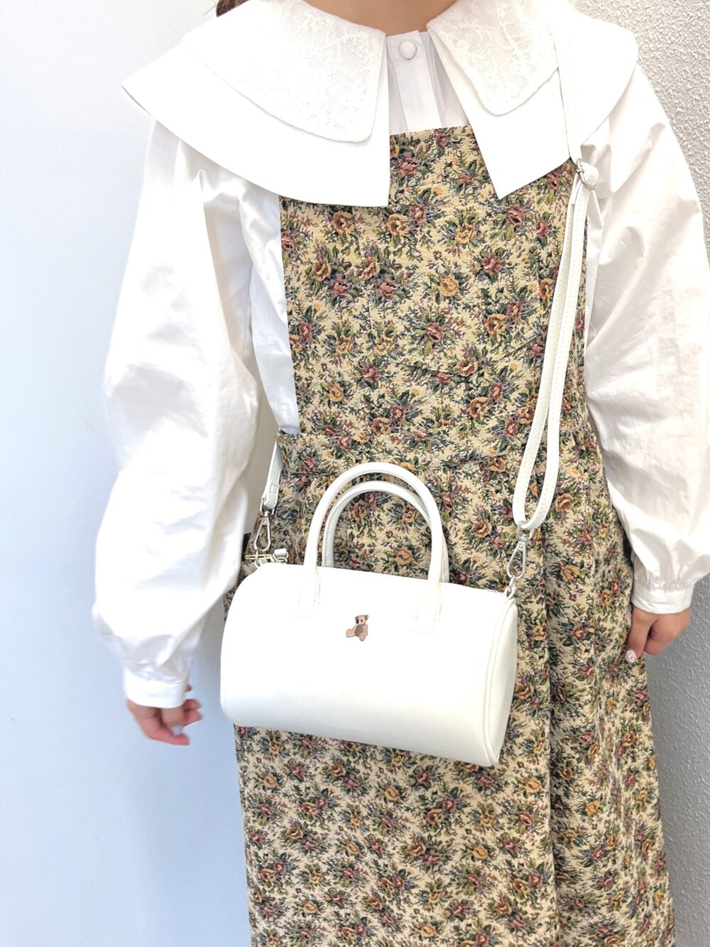 ベージュ系のジャンパースカート、ホワイト系のハンドバッグ、ホワイト系のサンダルを着用したレディースの秋コーディネートの6枚目の写真