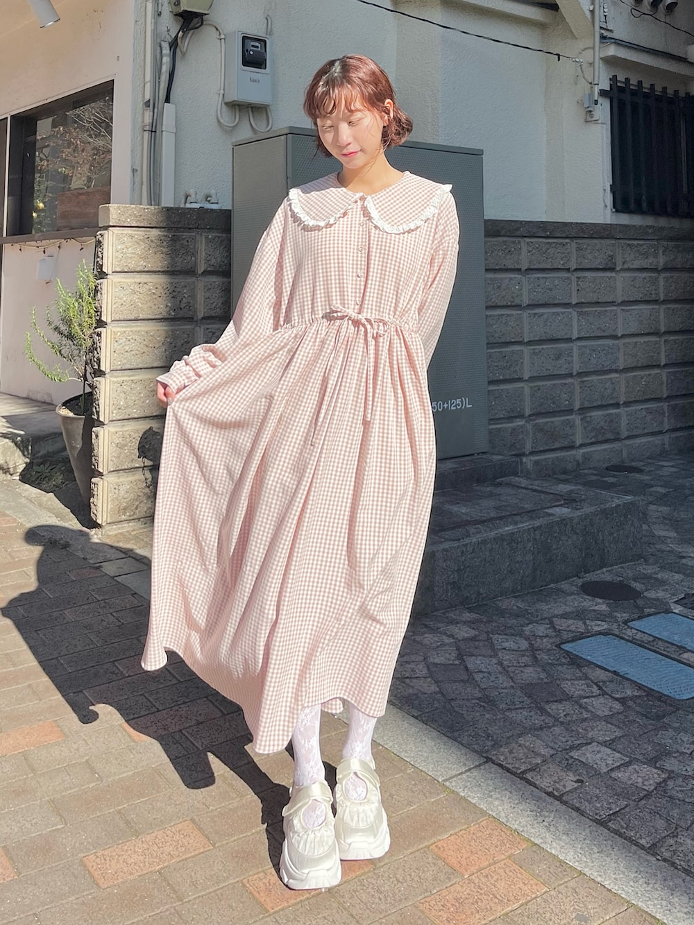 ピンク系のワンピース、ピンク系のジャージ、ホワイト系のスニーカーを着用したレディースの冬コーディネートの7枚目の写真