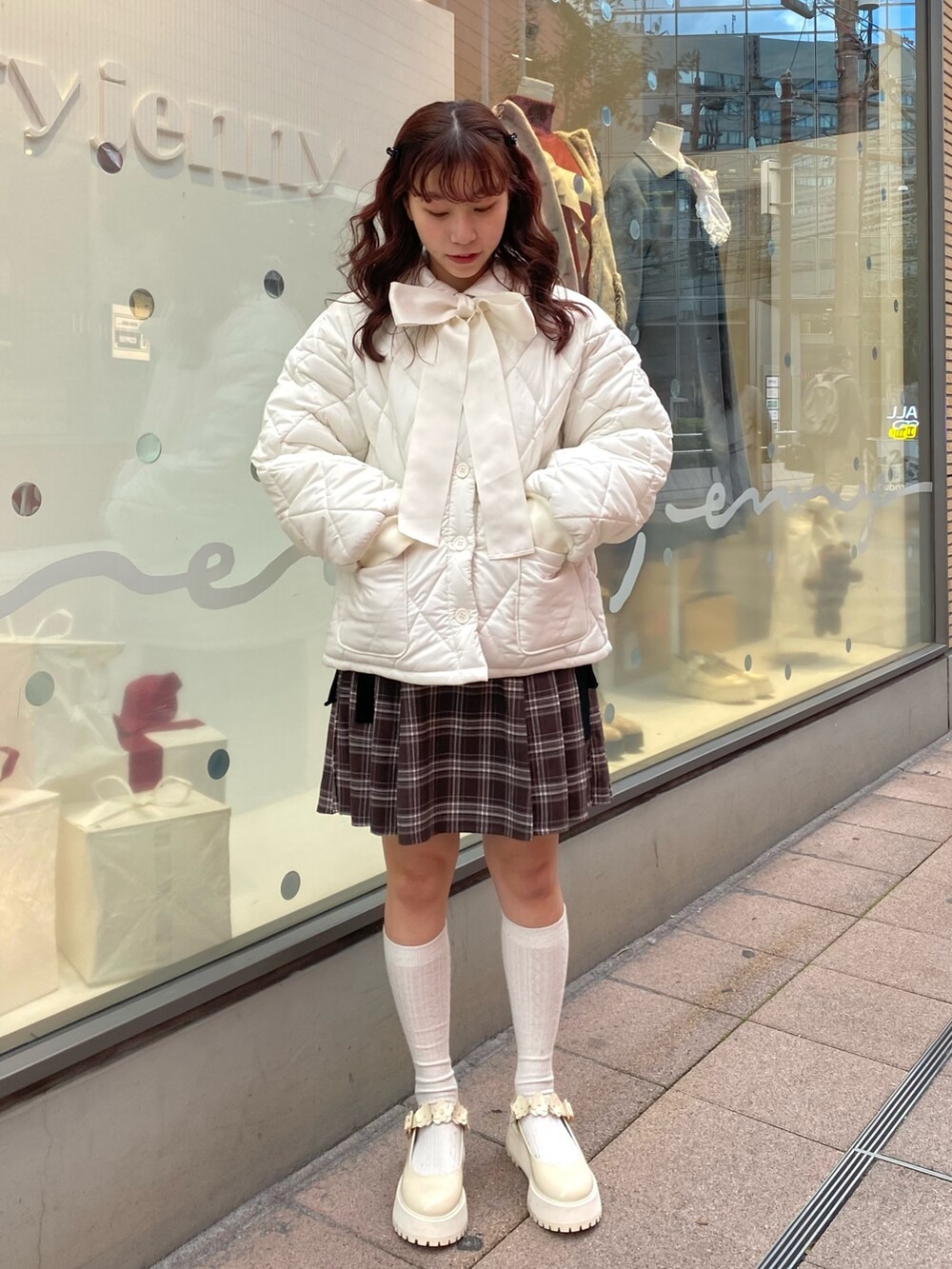 ホワイト系のその他アウター、ブラウン系のスカート、ホワイト系のローファーを着用したレディースの冬コーディネートの2枚目の写真