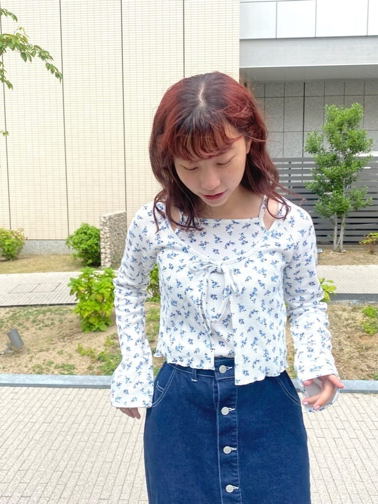 ホワイト系のサンダル、ブルー系のスカート、ホワイト系のアンサンブルを着用したレディースの秋コーディネートの4枚目の写真