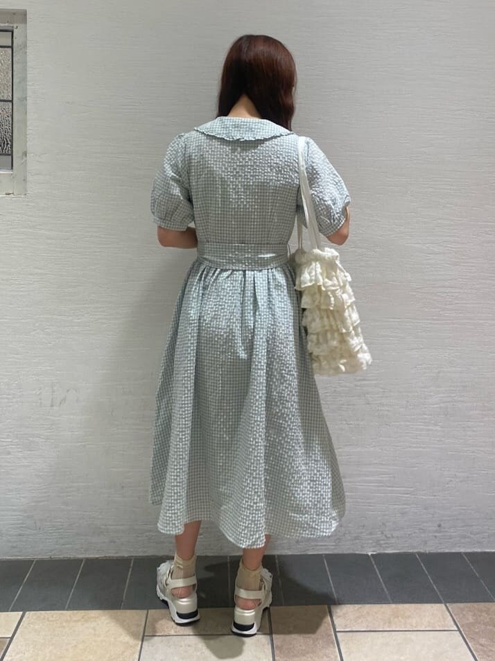 ホワイト系のサンダル、ホワイト系のトートバッグ、グリーン系のワンピースを着用したレディースの春コーディネートの4枚目の写真