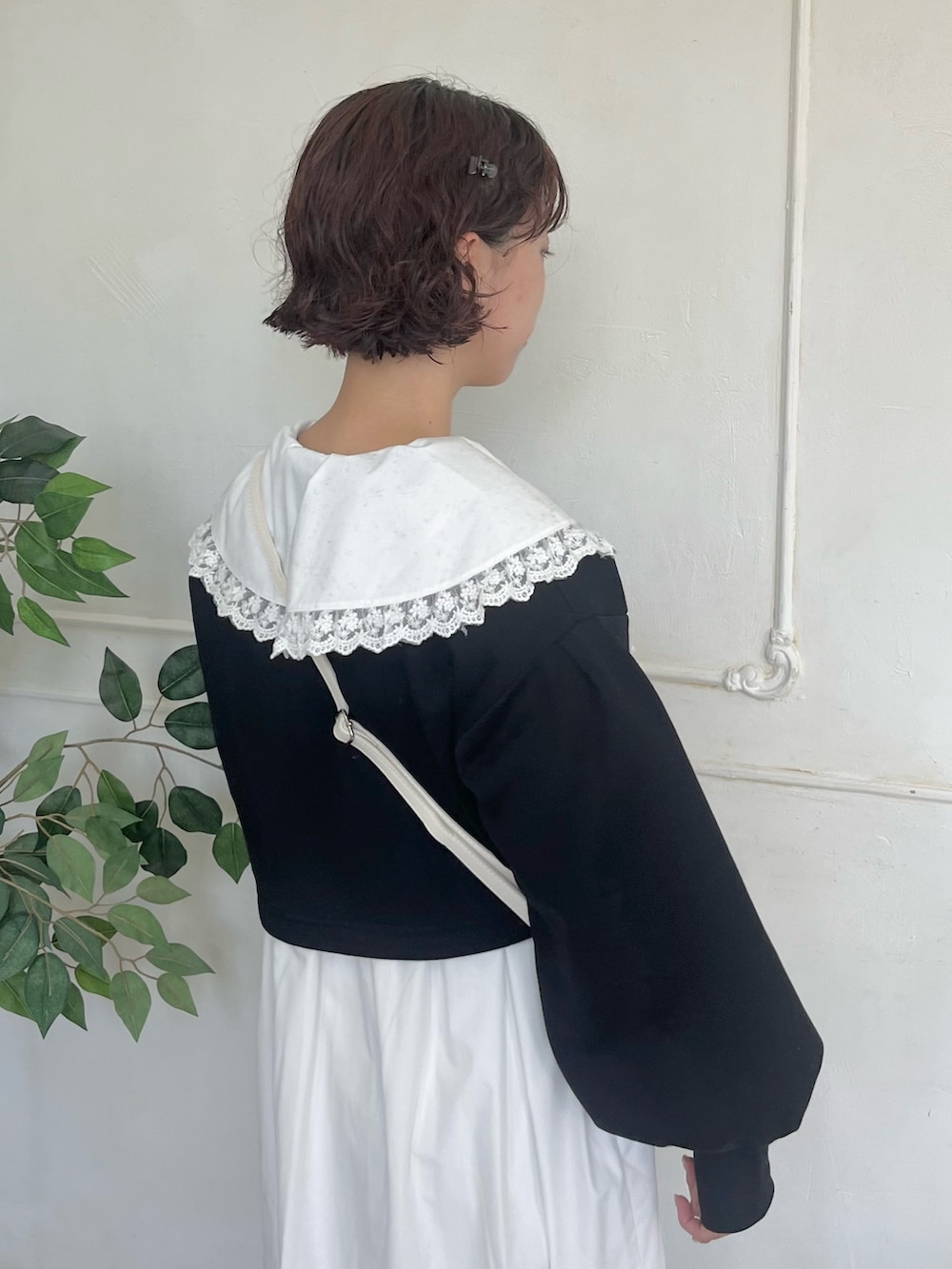 ホワイト系のワンピース、ブラック系のカーディガン/ボレロ、ホワイト系のショルダーバッグを着用したレディースの秋コーディネートの5枚目の写真