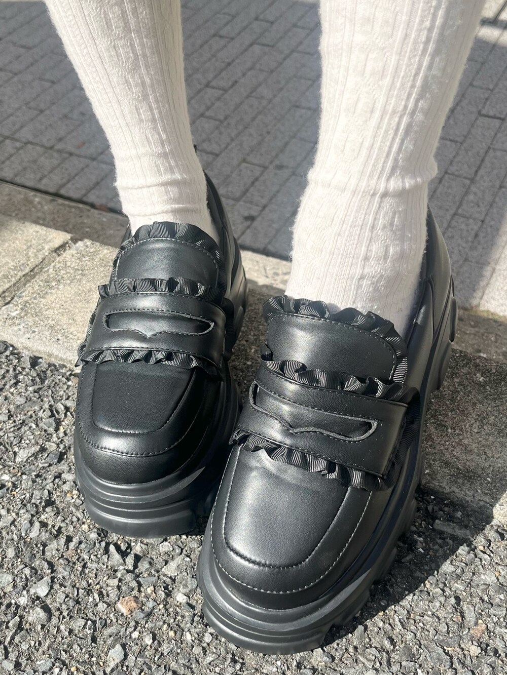 ピンク系のニット/セーター、ブラック系のスカート、ブラック系のローファーを着用したレディースの冬コーディネートの10枚目の写真