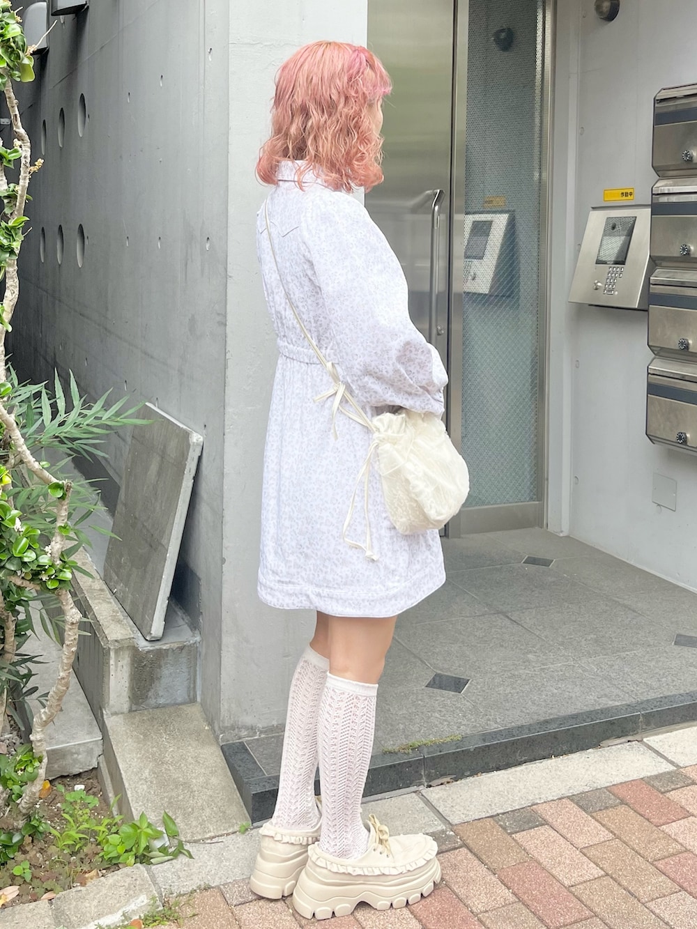 ホワイト系のワンピース、ホワイト系のショルダーバッグ、ベージュ系のローファーを着用したレディースの夏コーディネートの2枚目の写真