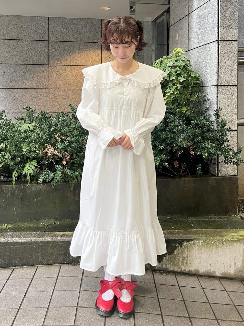 レッド系のカーディガン/ボレロ、ホワイト系のワンピース、レッド系のバレエシューズを着用したレディースの秋コーディネートの8枚目の写真