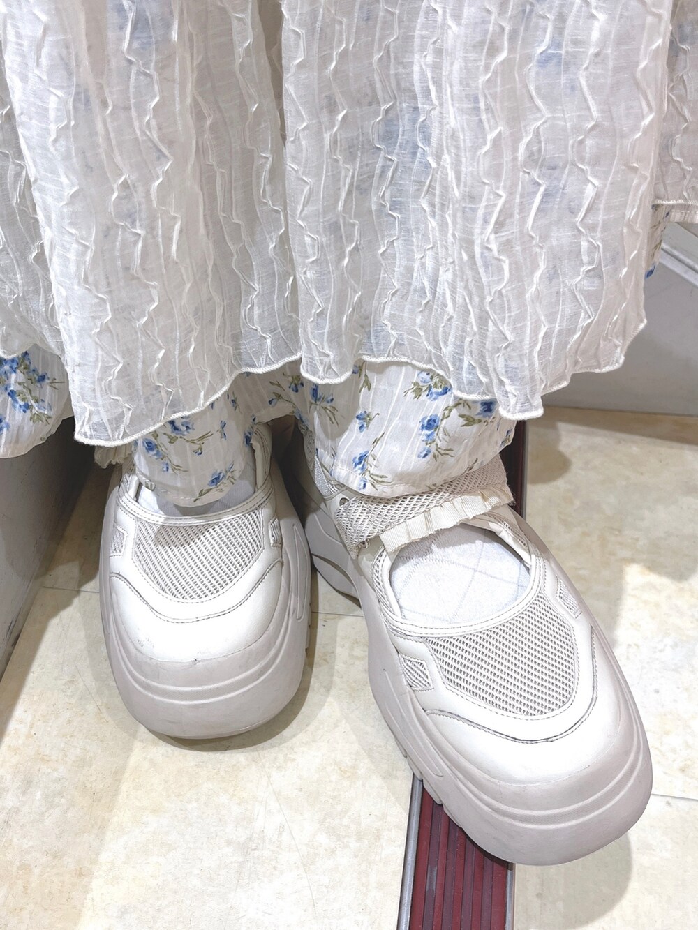 ホワイト系のスウェット、ブルー系のスカート、ホワイト系のスニーカーを着用したレディースの冬コーディネートの10枚目の写真