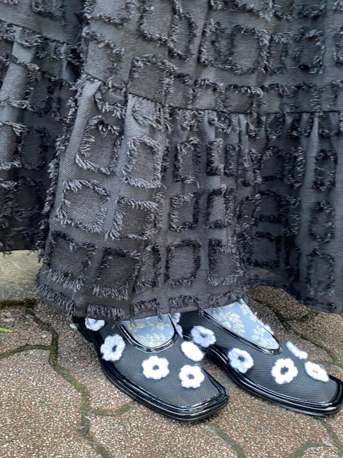 ブラック系のワンピース、ブラック系のパンプス、その他のハンドバッグを着用したレディースの秋コーディネートの6枚目の写真