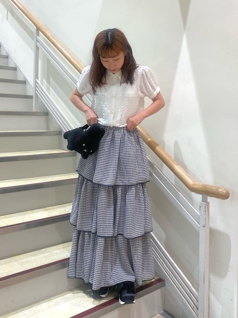 ブラック系のスニーカー、ホワイト系のシャツ/ブラウス、ブラック系のスカートを着用したレディースの夏コーディネートの2枚目の写真