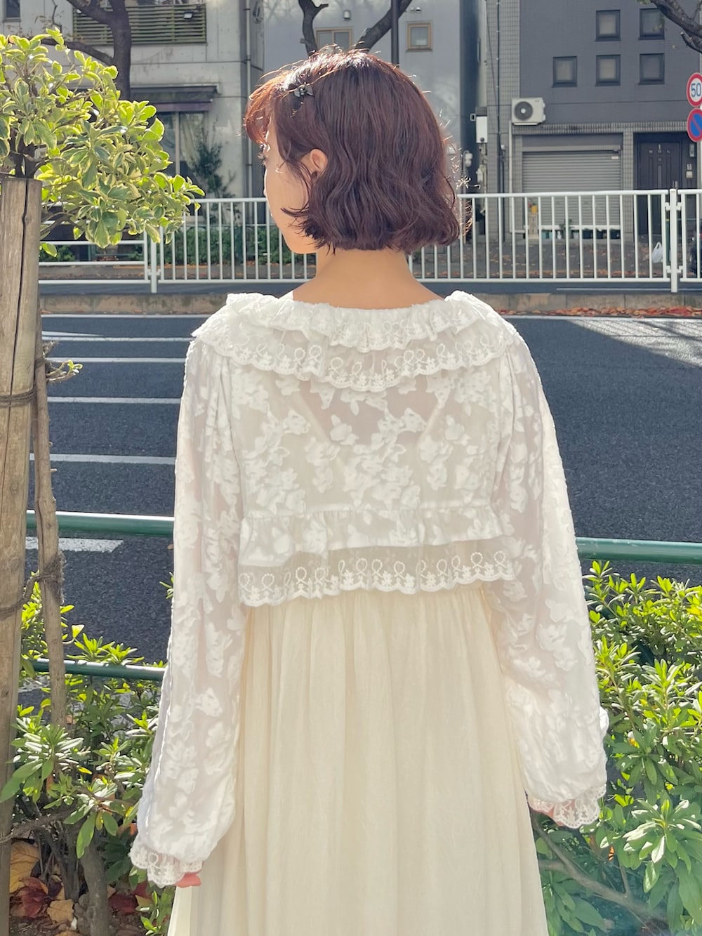 ホワイト系のカーディガン/ボレロ、ホワイト系のワンピース、ベージュ系のサンダルを着用したレディースの冬コーディネートの6枚目の写真