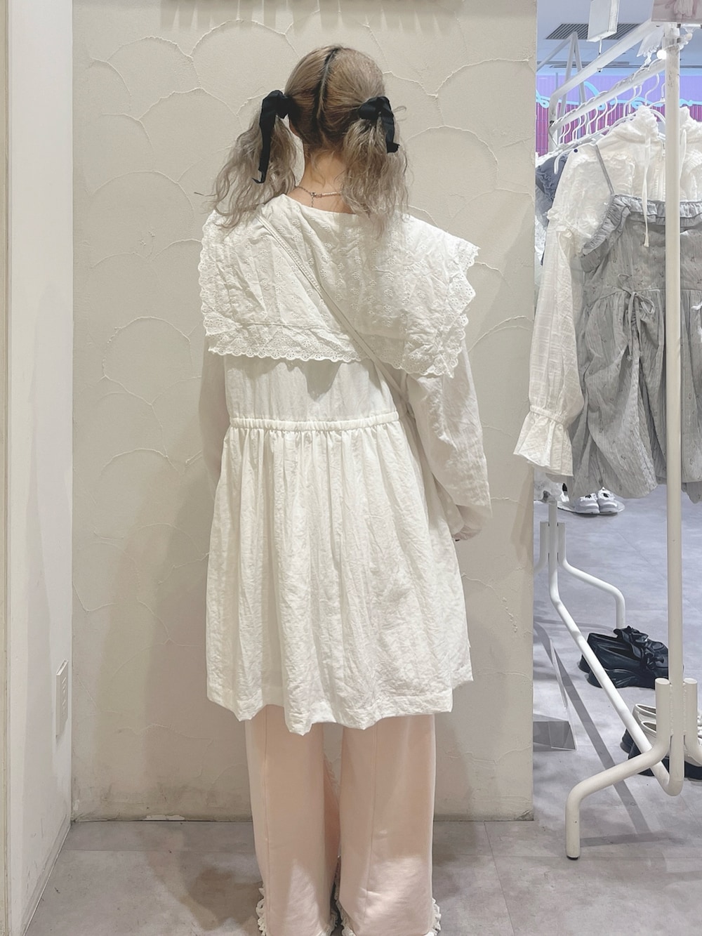 ホワイト系のワンピース、ピンク系のスウェットパンツ、ホワイト系のショルダーバッグを着用したレディースの春コーディネートの3枚目の写真