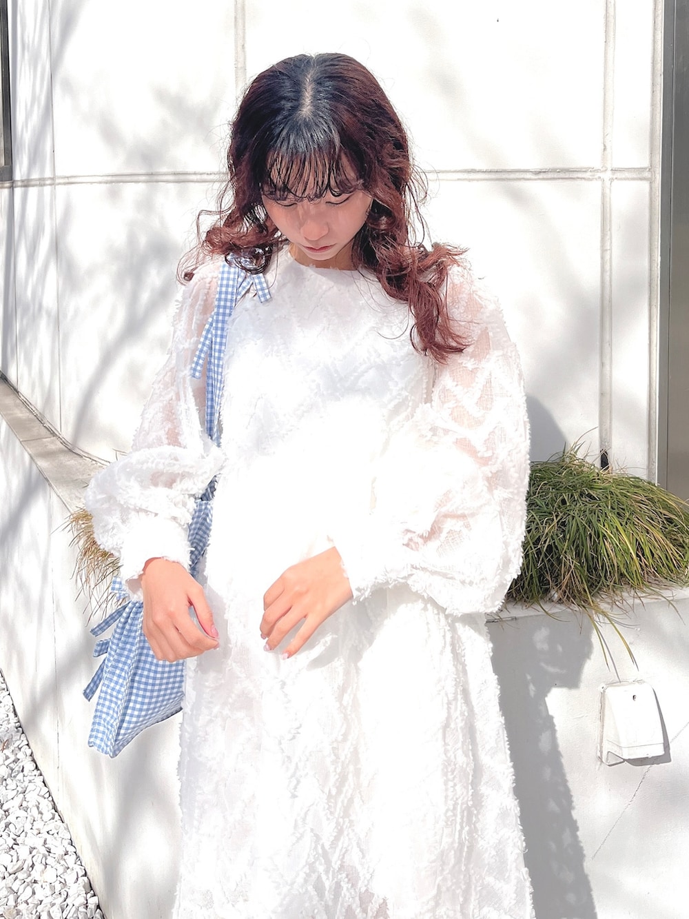 ホワイト系のワンピース、ブルー系のトートバッグ、ホワイト系のバレエシューズを着用したレディースの冬コーディネートの7枚目の写真