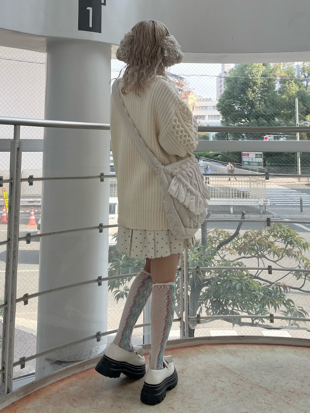 ホワイト系のカーディガン/ボレロ、ホワイト系のスカート、ベージュ系のショルダーバッグを着用したレディースの冬コーディネートの3枚目の写真