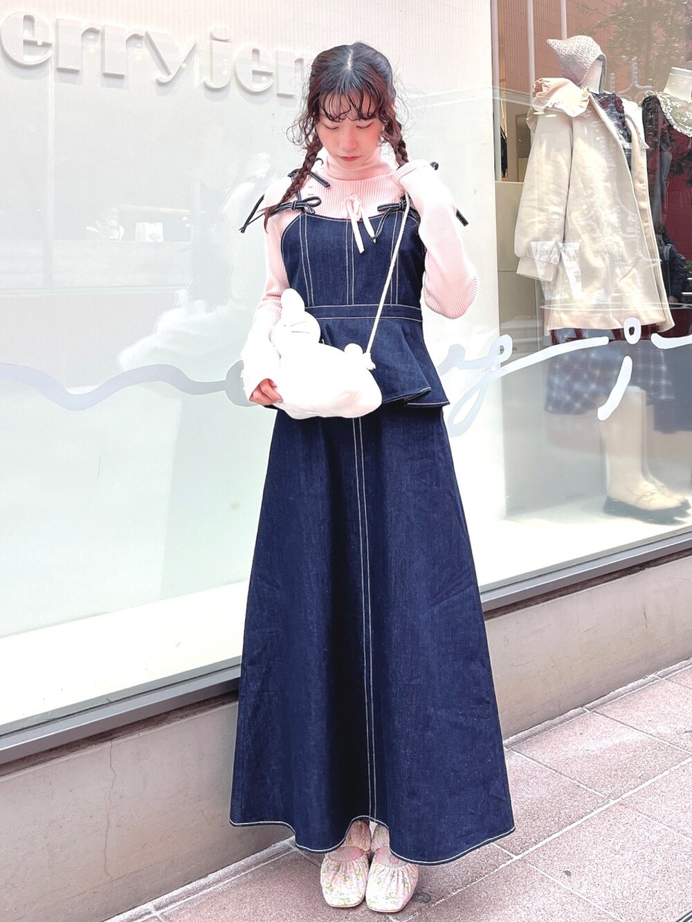 ピンク系のニット/セーター、ブルー系のワンピース、ホワイト系のショルダーバッグを着用したレディースの冬コーディネートの2枚目の写真