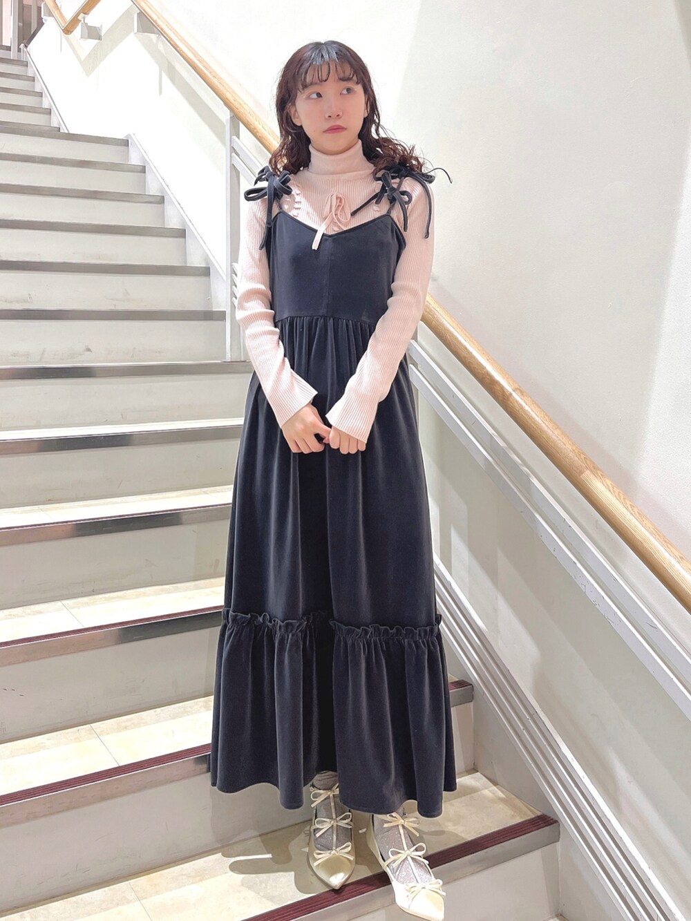 ピンク系のニット/セーター、グレー系のワンピース、ホワイト系のパンプスを着用したレディースの冬コーディネートの2枚目の写真