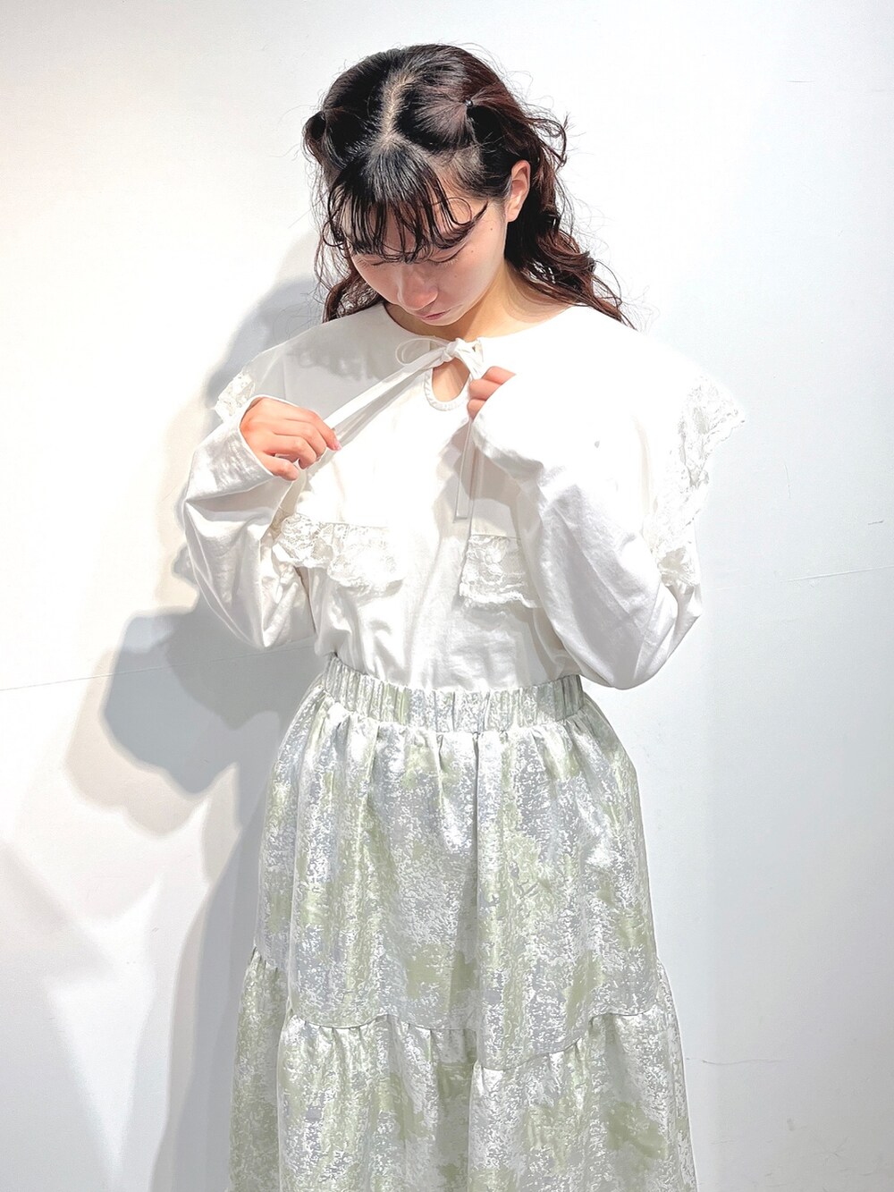 ホワイト系のTシャツ/カットソー、グリーン系のスカート、ホワイト系のパンプスを着用したレディースの冬コーディネートの7枚目の写真