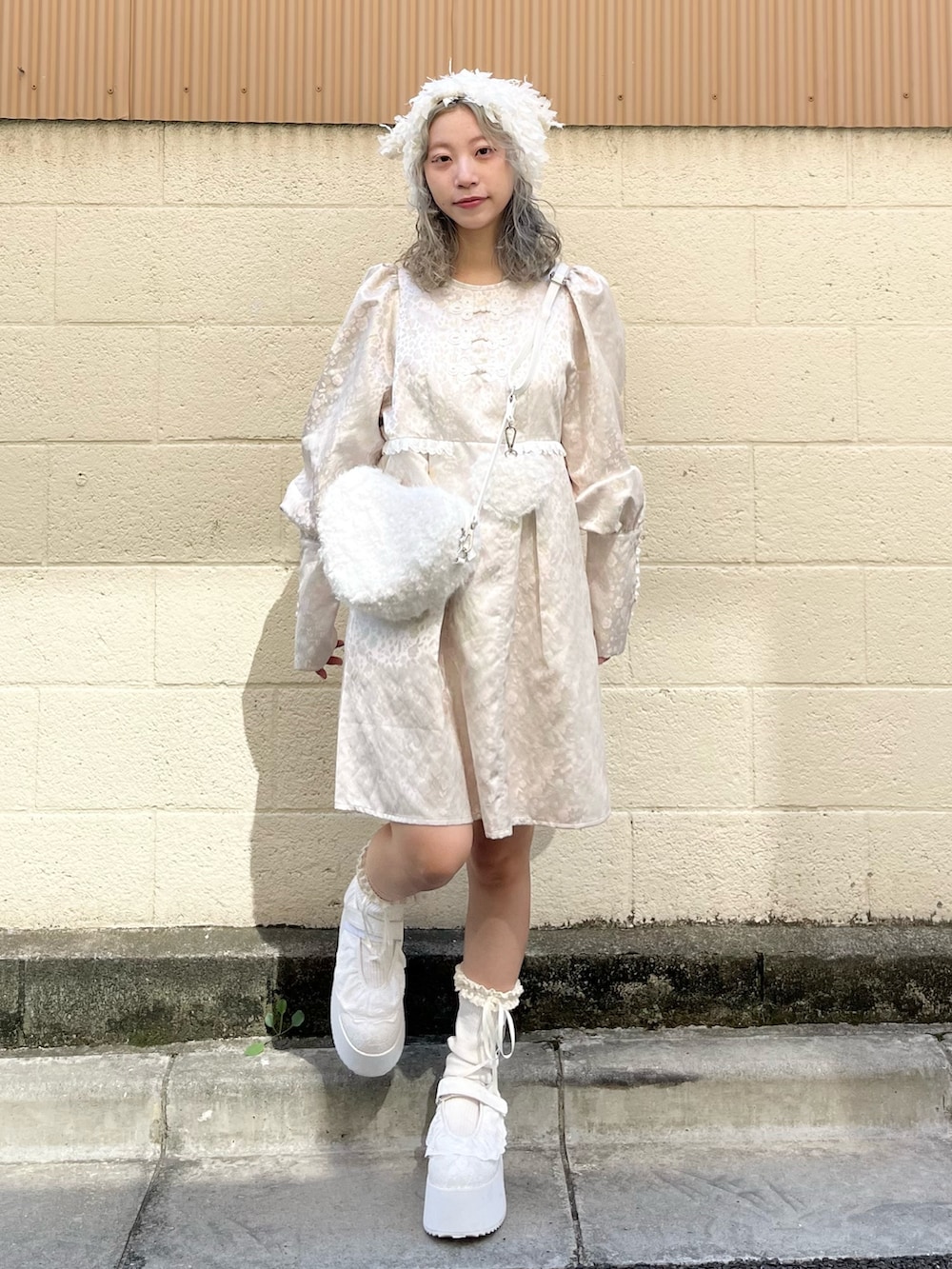 ピンク系のワンピース、ホワイト系のショルダーバッグ、ホワイト系のスニーカーを着用したレディースの秋コーディネートの2枚目の写真