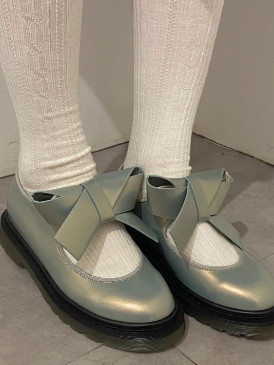 ブルー系のワンピース、ホワイト系のパンプス、グレー系のカーディガン/ボレロを着用したレディースの秋コーディネートの4枚目の写真