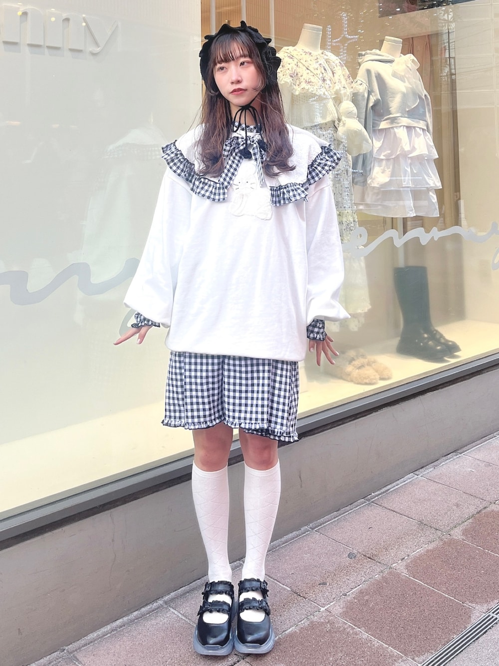 ホワイト系のスウェット、ブラック系のワンピース、ブラック系のスニーカーを着用したレディースの冬コーディネートの2枚目の写真