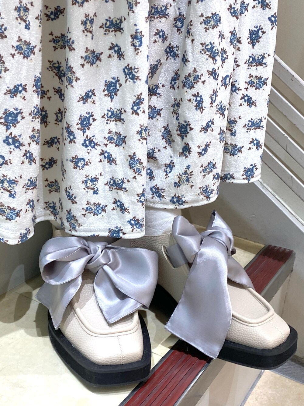 ブルー系のその他アウター、ホワイト系のニット/セーター、ホワイト系のスカートを着用したレディースの秋コーディネートの4枚目の写真