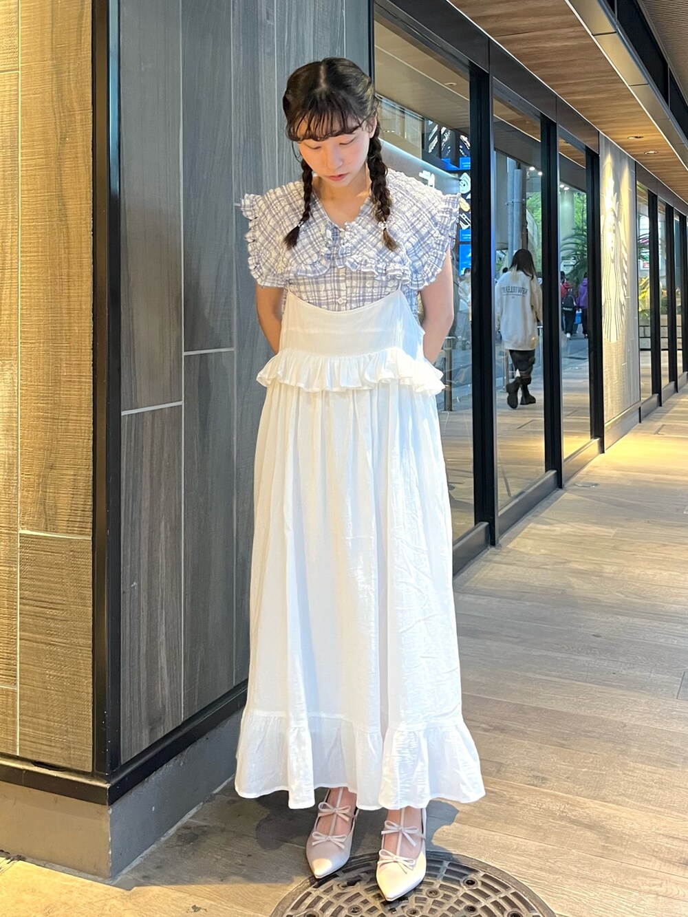 ブルー系のシャツ/ブラウス、ホワイト系のスカート、ブラウン系のパンプスを着用したレディースの春コーディネートの2枚目の写真