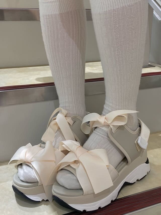 ブラック系のスカート、ホワイト系のサンダル、ホワイト系のショルダーバッグを着用したレディースの春コーディネートの8枚目の写真