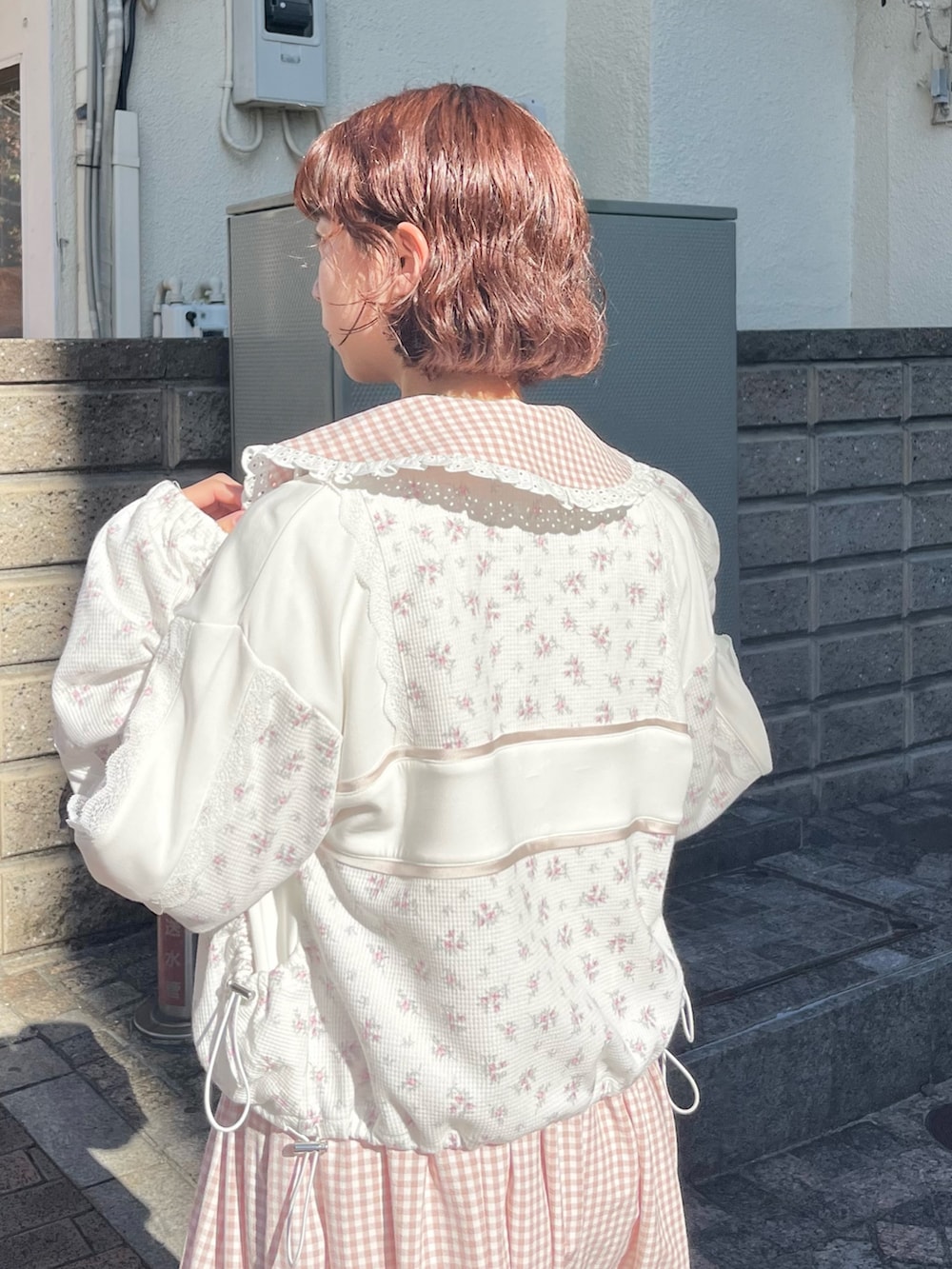 ピンク系のワンピース、ピンク系のジャージ、ホワイト系のスニーカーを着用したレディースの冬コーディネートの4枚目の写真