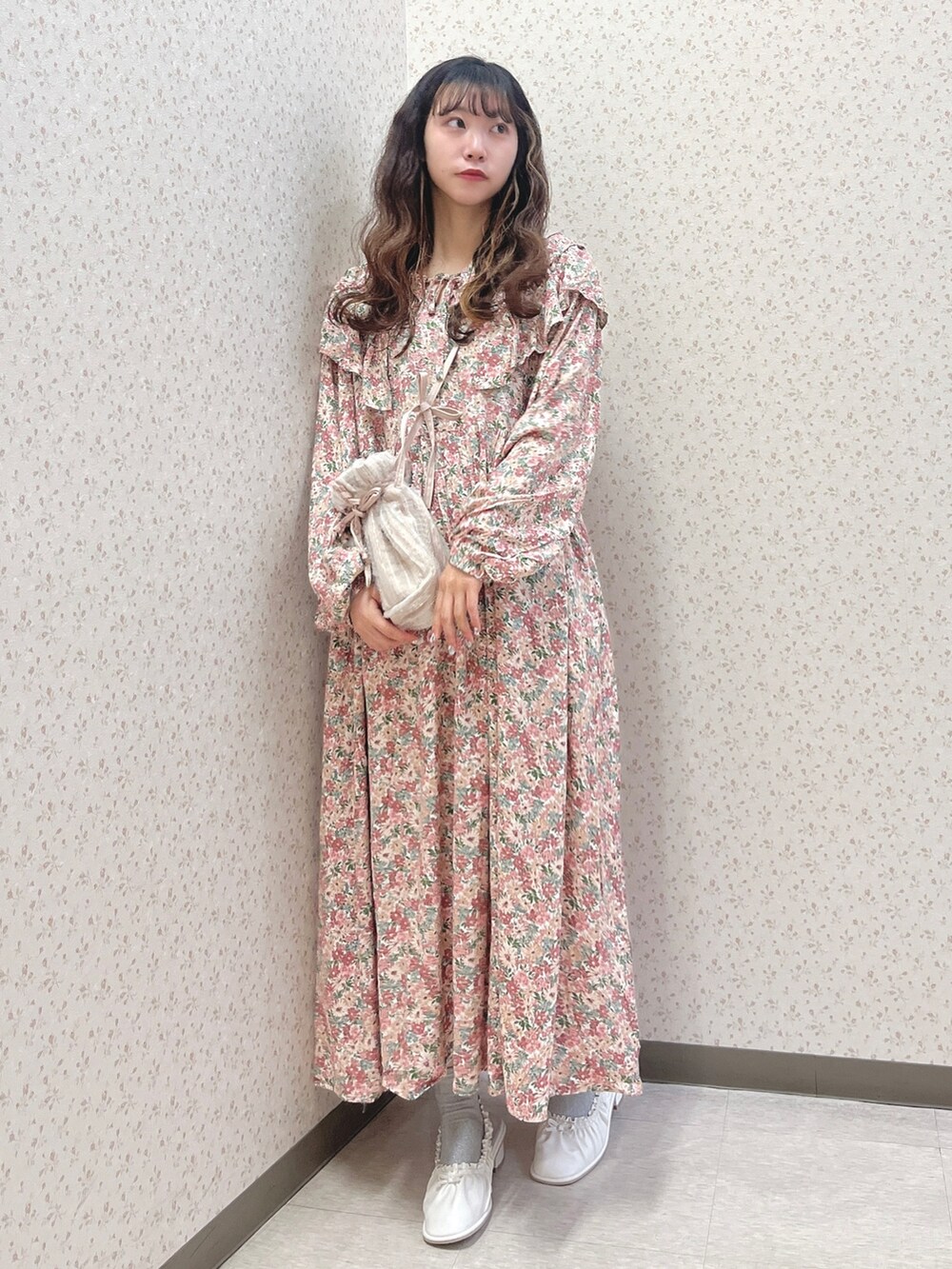 ピンク系のワンピース、ピンク系のショルダーバッグ、ホワイト系のパンプスを着用したレディースの春コーディネートの2枚目の写真