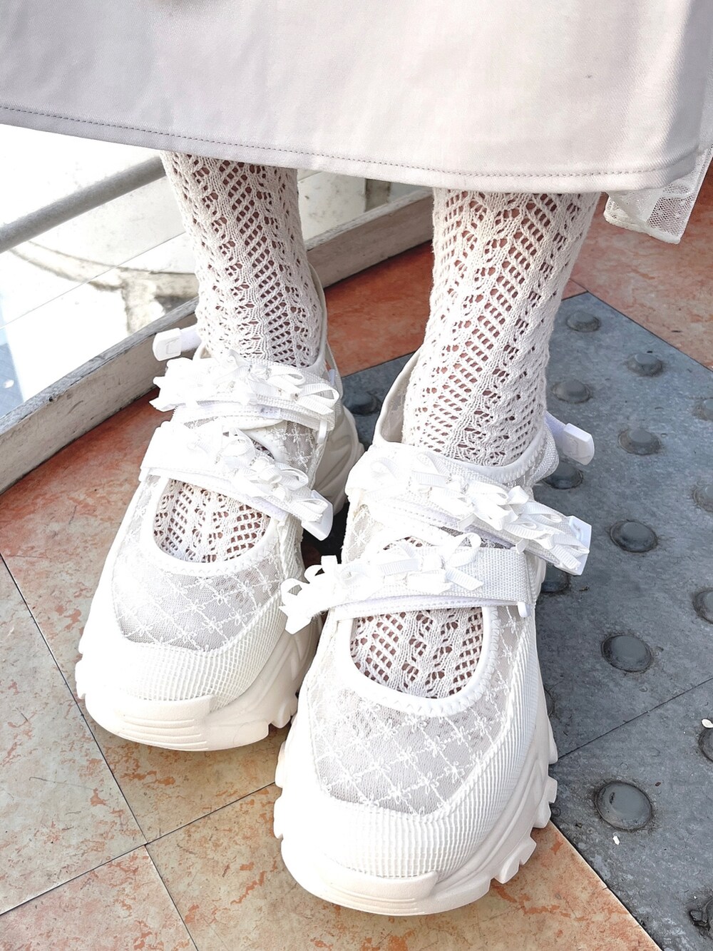 ブルー系のワンピース、ホワイト系のカーディガン/ボレロ、ホワイト系のトートバッグを着用したレディースの冬コーディネートの10枚目の写真