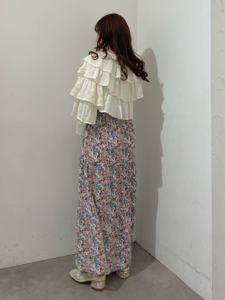 ピンク系のワンピース、ホワイト系のカーディガン/ボレロ、ホワイト系のパンプスを着用したレディースの冬コーディネートの2枚目の写真