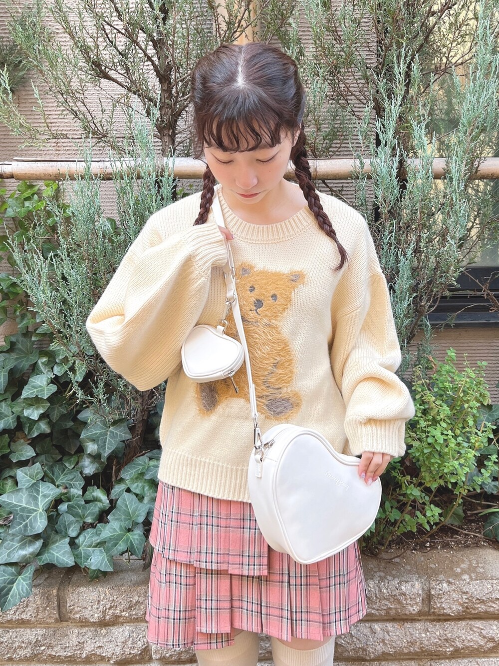 ホワイト系のニット/セーター、ホワイト系のショルダーバッグ、ピンク系のスカートを着用したレディースの秋コーディネートの5枚目の写真