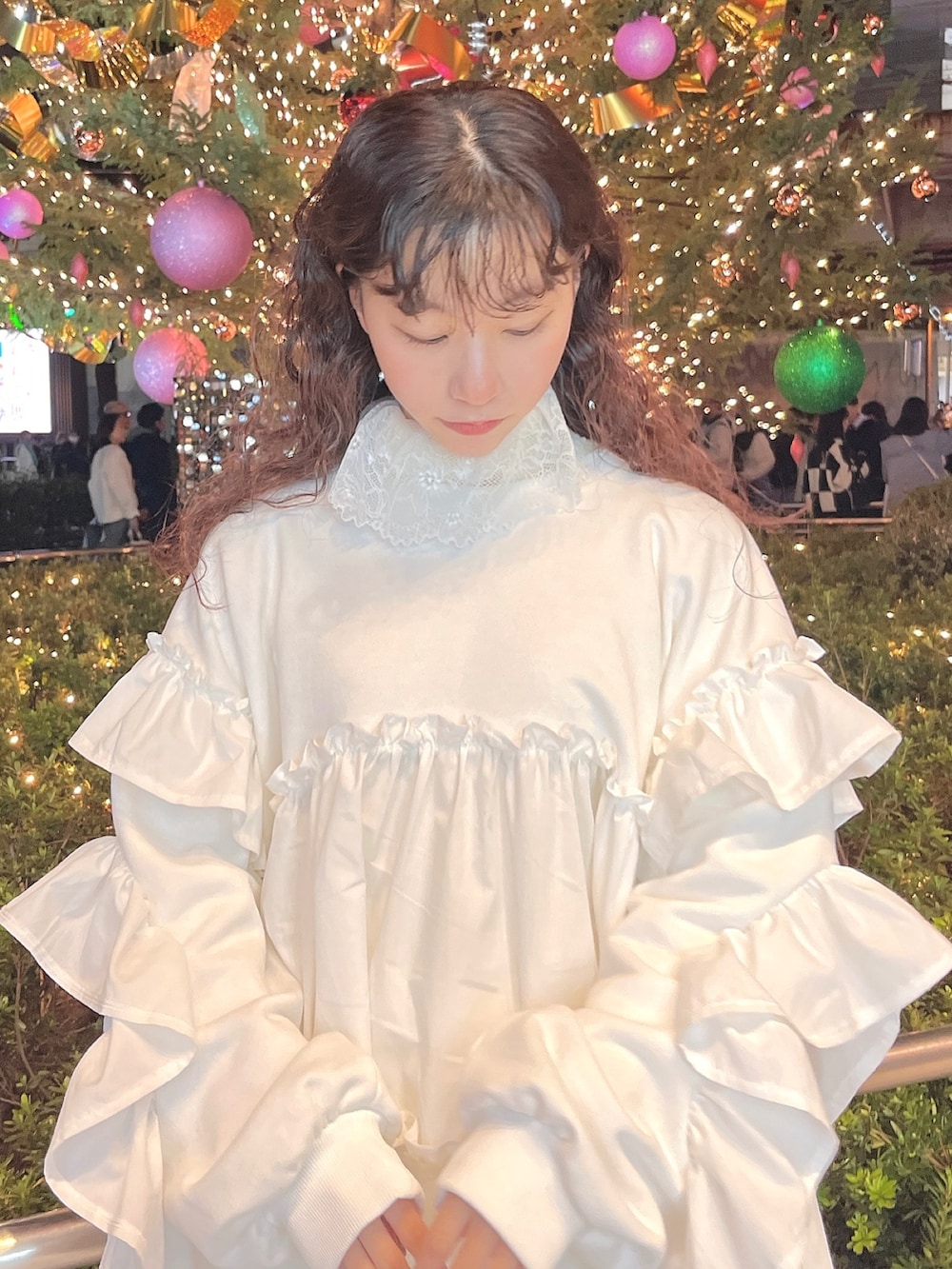 レッド系のチェスターコート、ホワイト系のニット/セーター、ホワイト系のスウェットを着用したレディースの冬コーディネートの9枚目の写真