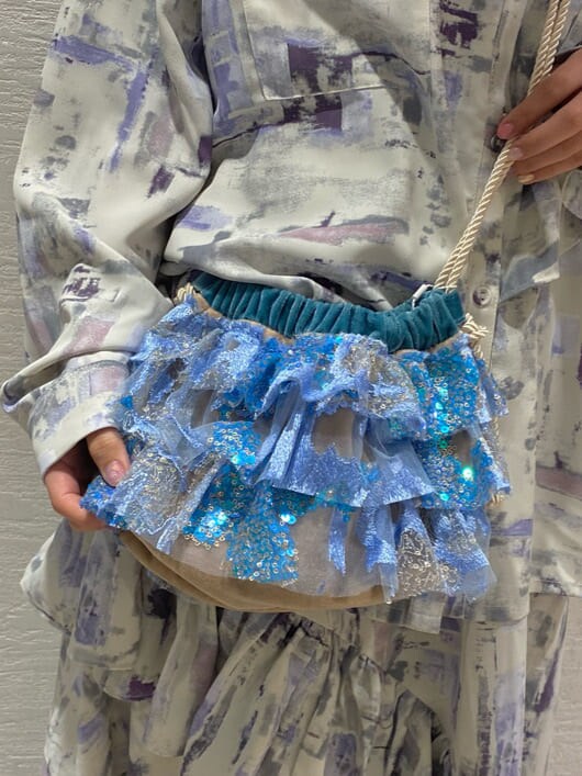 パープル系のシャツ/ブラウス、パープル系のスカート、ブルー系のサンダルを着用したレディースの冬コーディネートの5枚目の写真