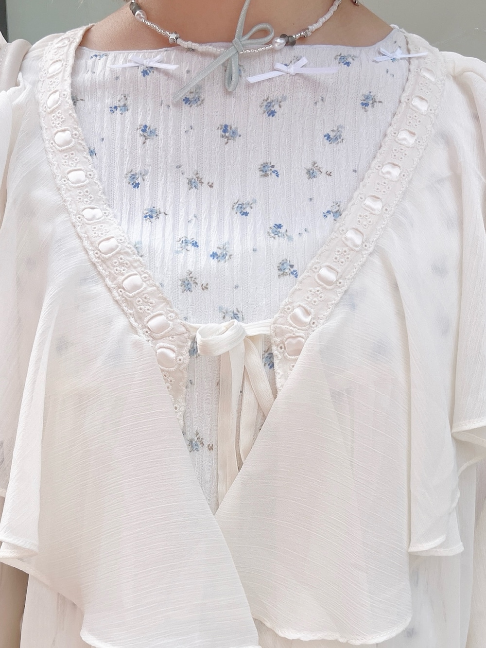 ホワイト系のカーディガン/ボレロ、ブルー系のTシャツ/カットソー、パープル系のスカートを着用したレディースの春コーディネートの8枚目の写真