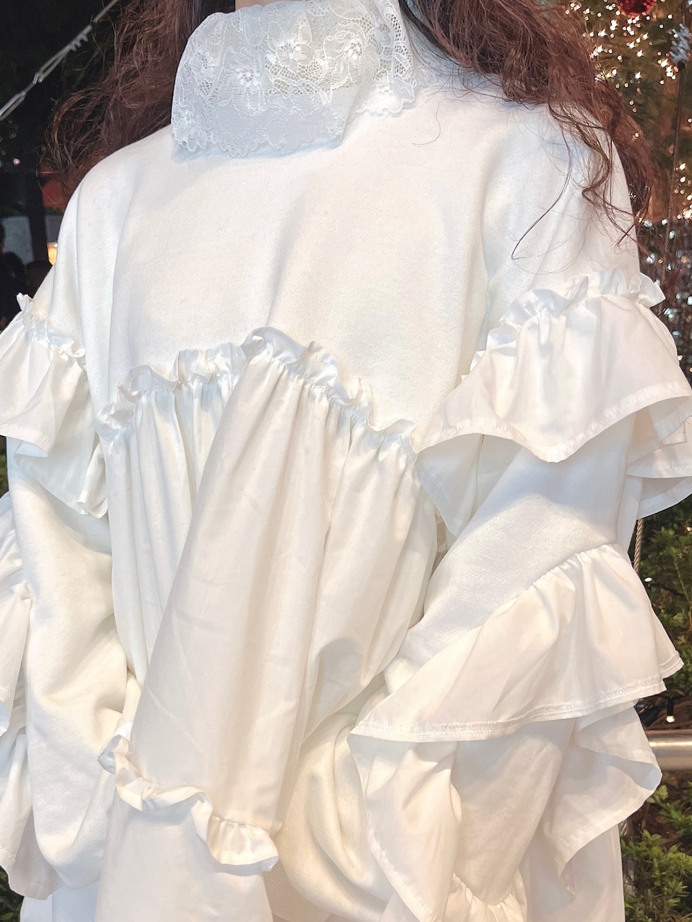 レッド系のチェスターコート、ホワイト系のニット/セーター、ホワイト系のスウェットを着用したレディースの冬コーディネートの10枚目の写真