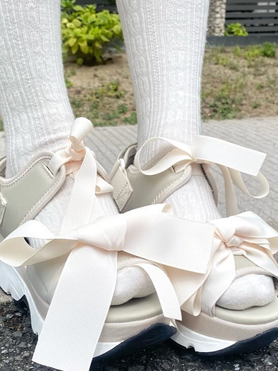 ホワイト系のサンダル、ブルー系のスカート、ホワイト系のアンサンブルを着用したレディースの秋コーディネートの5枚目の写真