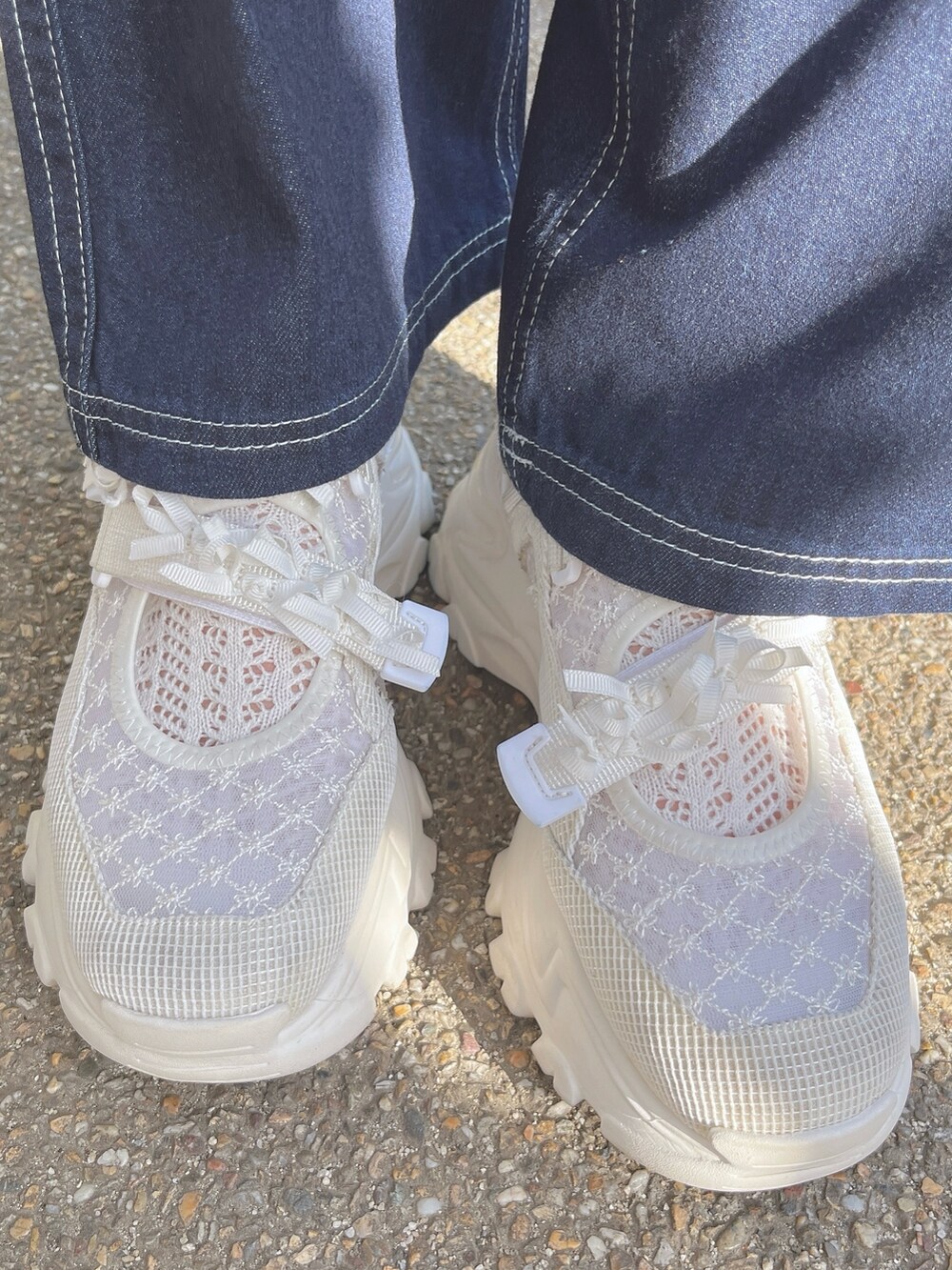 ホワイト系のTシャツ/カットソー、ブルー系のデニムパンツ、ホワイト系のスニーカーを着用したレディースの春コーディネートの6枚目の写真