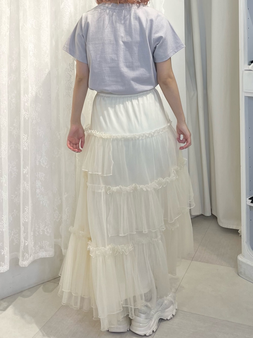 ブルー系のTシャツ/カットソー、ホワイト系のスカート、ホワイト系のスニーカーを着用したレディースの春コーディネートの5枚目の写真