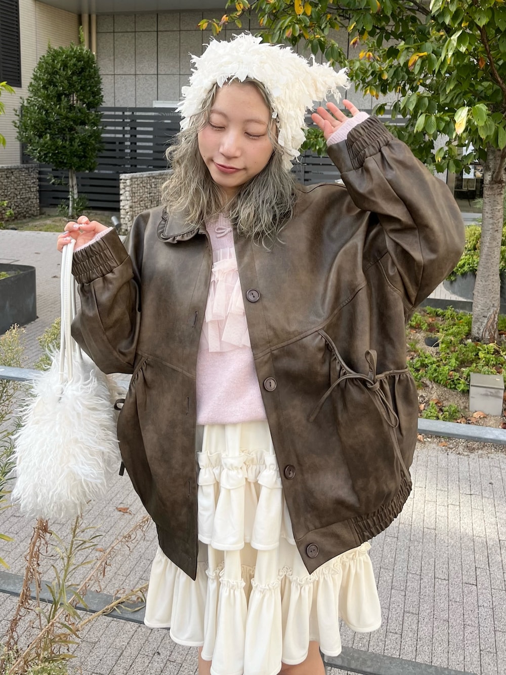 ブラウン系のブルゾン、ピンク系のニット/セーター、ホワイト系のボストンバッグを着用したレディースの秋コーディネートの4枚目の写真