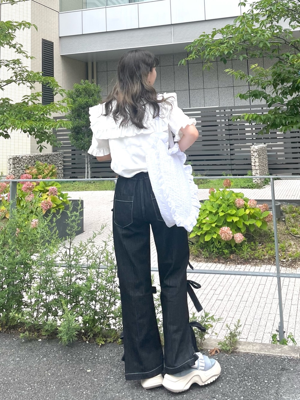 ホワイト系のシャツ/ブラウス、ブラック系のデニムパンツ、ホワイト系のトートバッグを着用したレディースの夏コーディネートの3枚目の写真