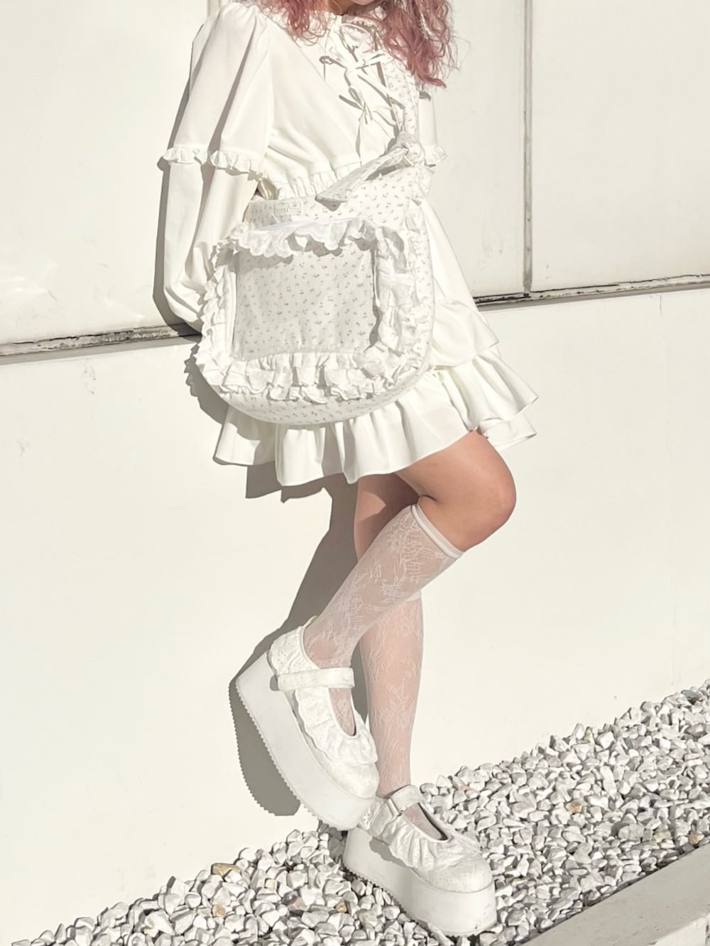 ホワイト系のワンピース、ピンク系のショルダーバッグ、ホワイト系のスニーカーを着用したレディースの冬コーディネートの3枚目の写真