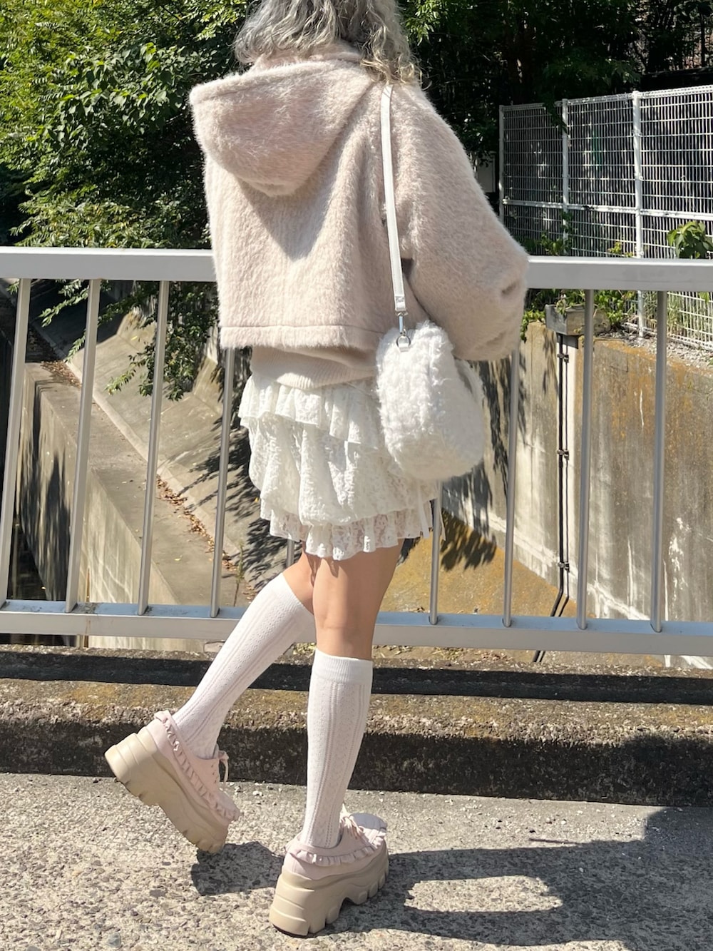 ピンク系のダッフルコート、ホワイト系のニット/セーター、ホワイト系のその他パンツを着用したレディースの秋コーディネートの4枚目の写真