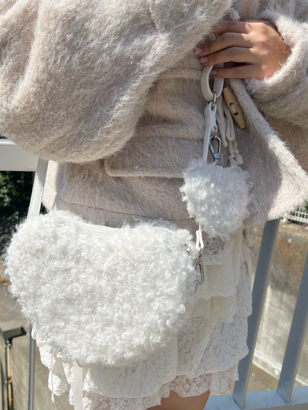 ピンク系のダッフルコート、ホワイト系のニット/セーター、ホワイト系のその他パンツを着用したレディースの秋コーディネートの9枚目の写真