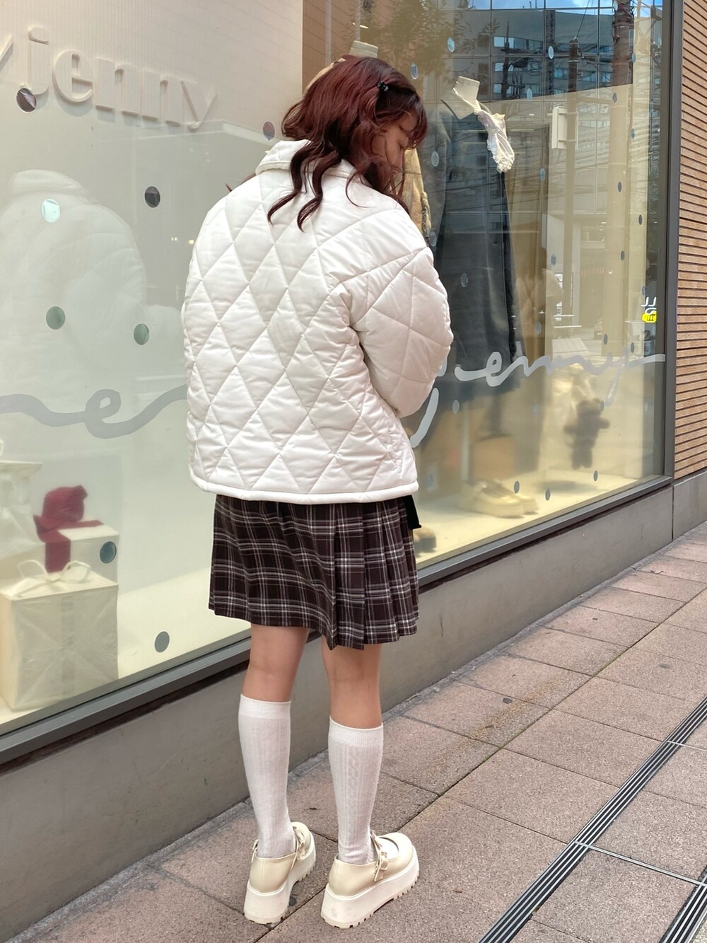 ホワイト系のその他アウター、ブラウン系のスカート、ホワイト系のローファーを着用したレディースの冬コーディネートの3枚目の写真